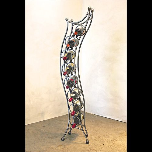 A metal wine rack with red bottles on top.
