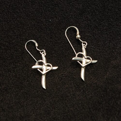 A pair of silver earrings with a cross and heart.