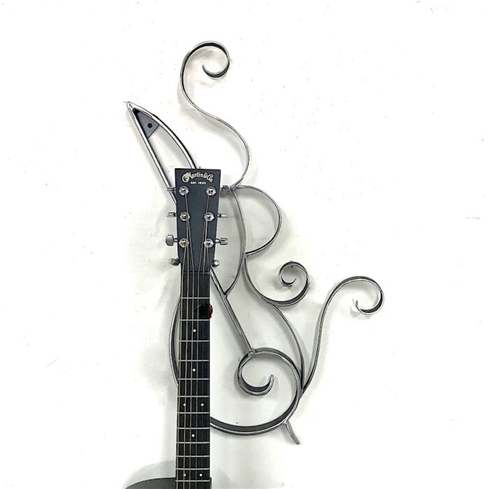 A guitar with a metal design on the wall.
