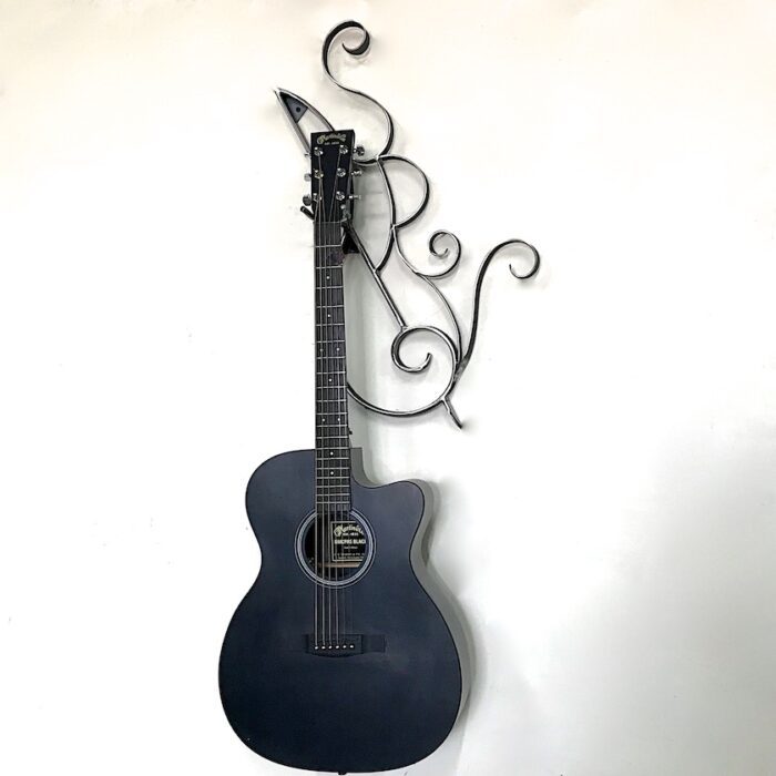A guitar hanging on the wall with a decorative metal hanger.