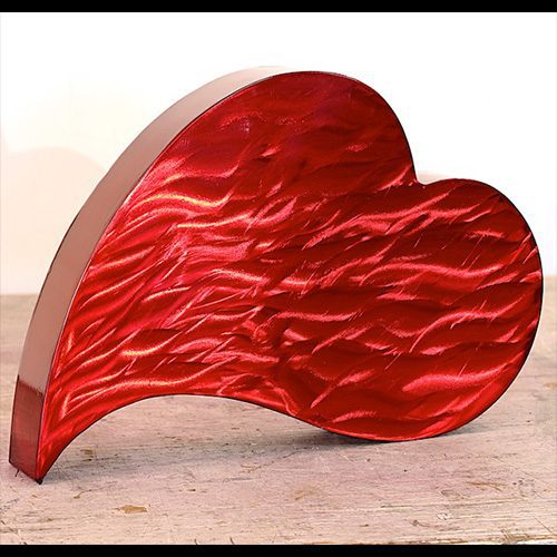 A red heart sculpture sitting on top of a table.