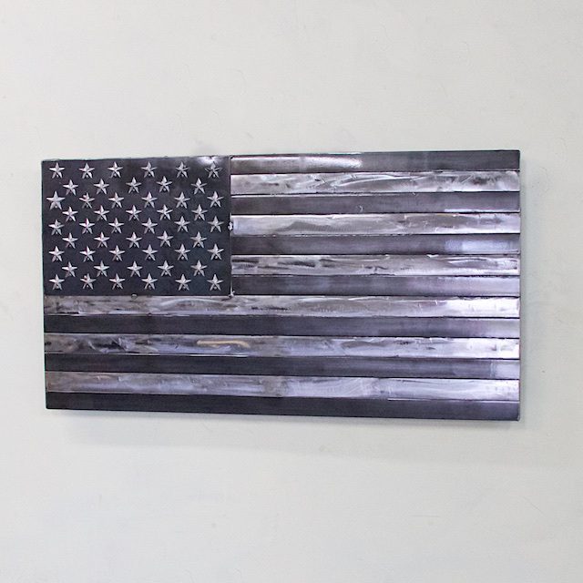 A metal american flag hanging on the wall.