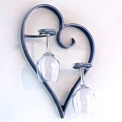 A heart shaped wine glass holder with two glasses.