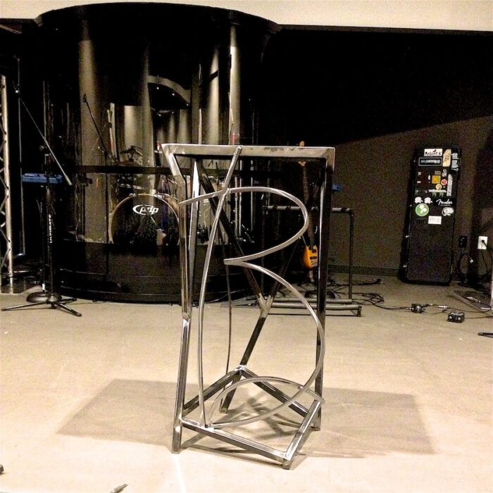A metal sculpture of a spiral staircase in the middle of a room.