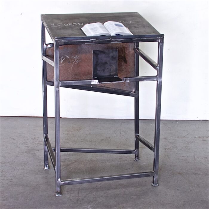 A metal table with a drawer and shelf.