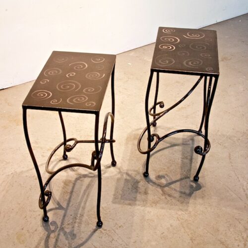Two metal tables with a design on them.