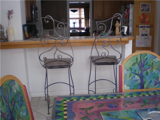 Two chairs are sitting in front of a bar.