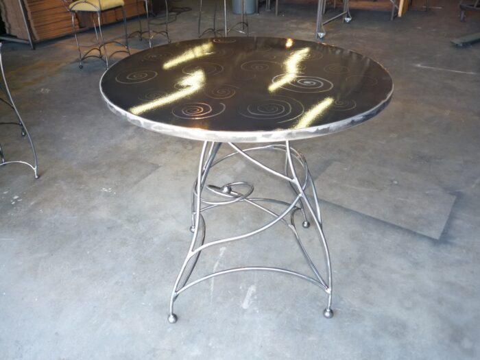 A table with metal legs and a black top.
