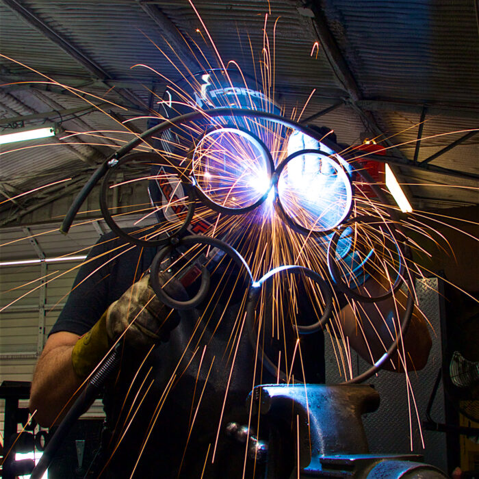 A person welding with sparks flying from their hands.