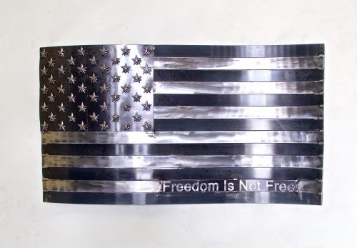 A metal american flag with the words " freedom is not free ".