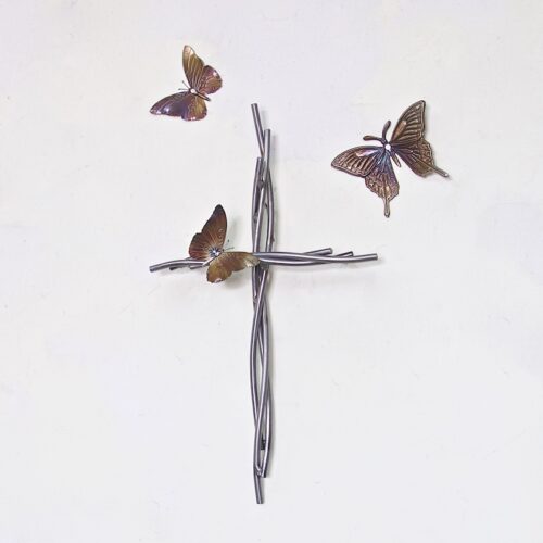 A cross with three butterflies flying around it.