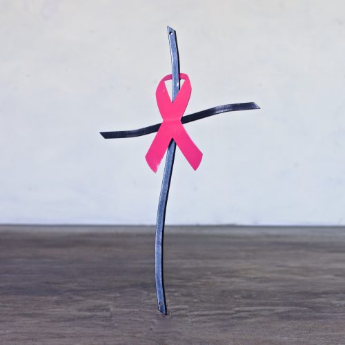 A cross with a pink ribbon on it.