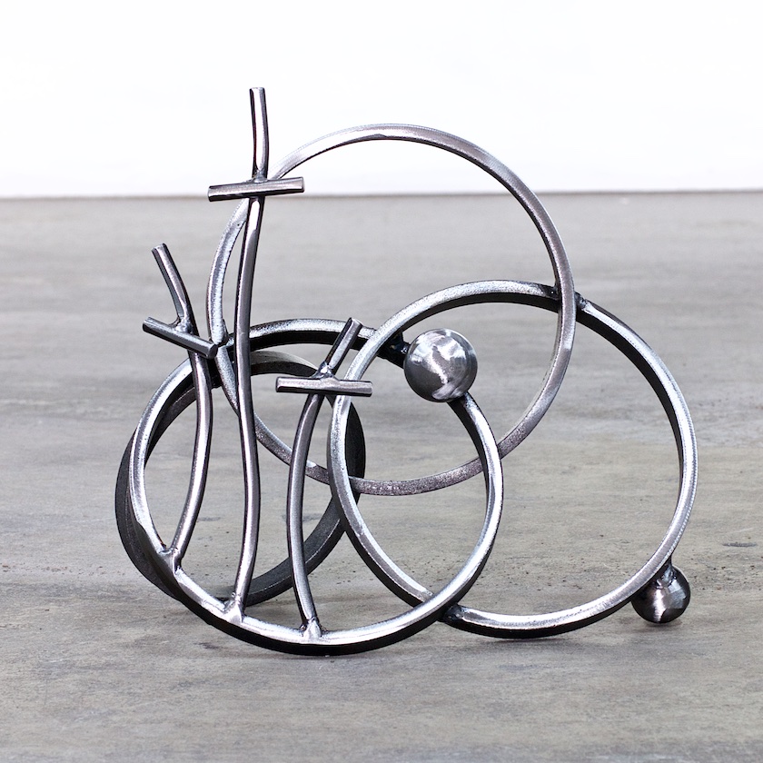 A metal sculpture of three circles and one is connected.