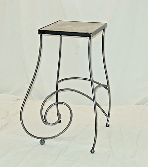 A metal stool with a wooden top and swirling legs.